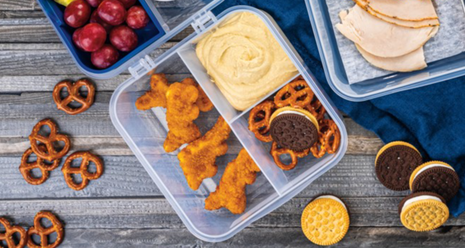 Image of bento box with chicken nuggets, cookies, pretzels, and hummus